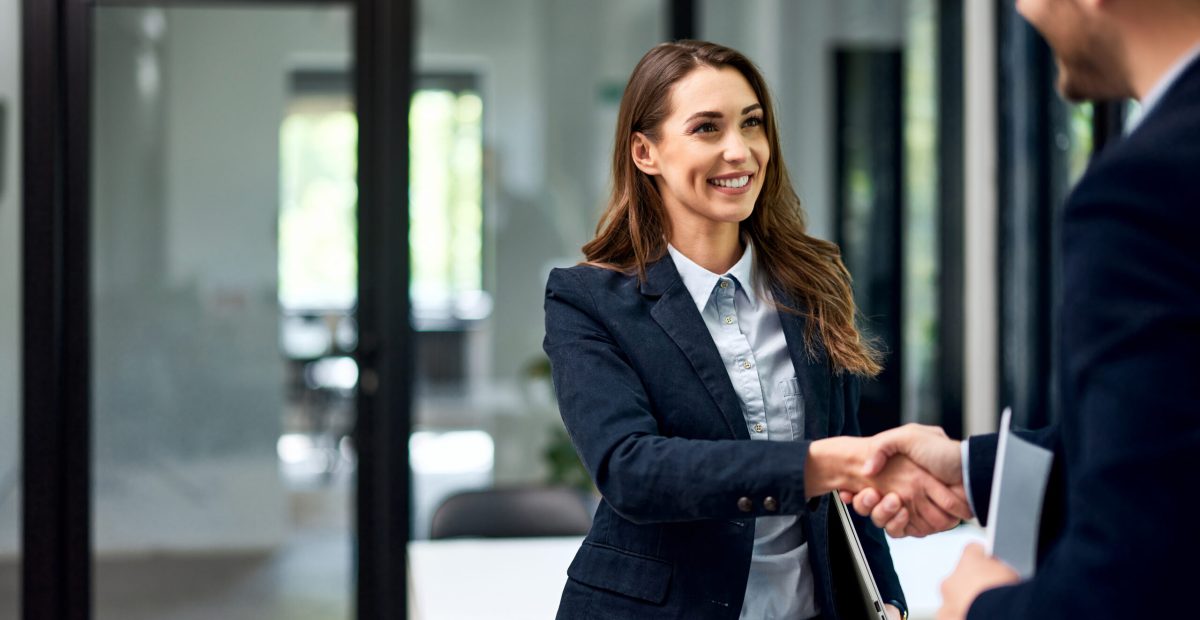 a smiling female employee handshake with a male boss at the offi